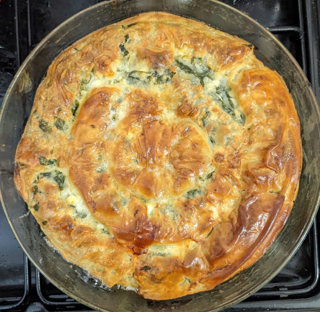 cheese and spinach bourekas recipe baked in a spiral in a round pan, golden and crispy