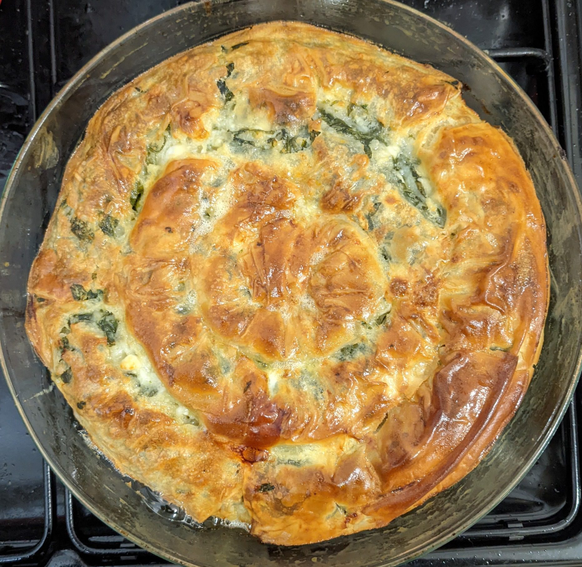 Cheese and spinach bourekas recipe baked in a spiral in a round pan, golden and crispy