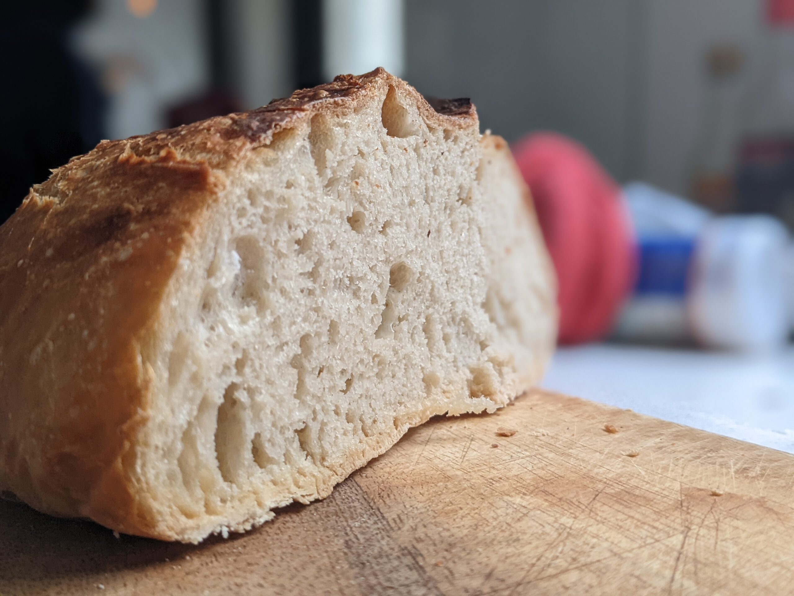 Close up of no knead Dutch oven bread crumb showing open airy texture and crispy crust edge