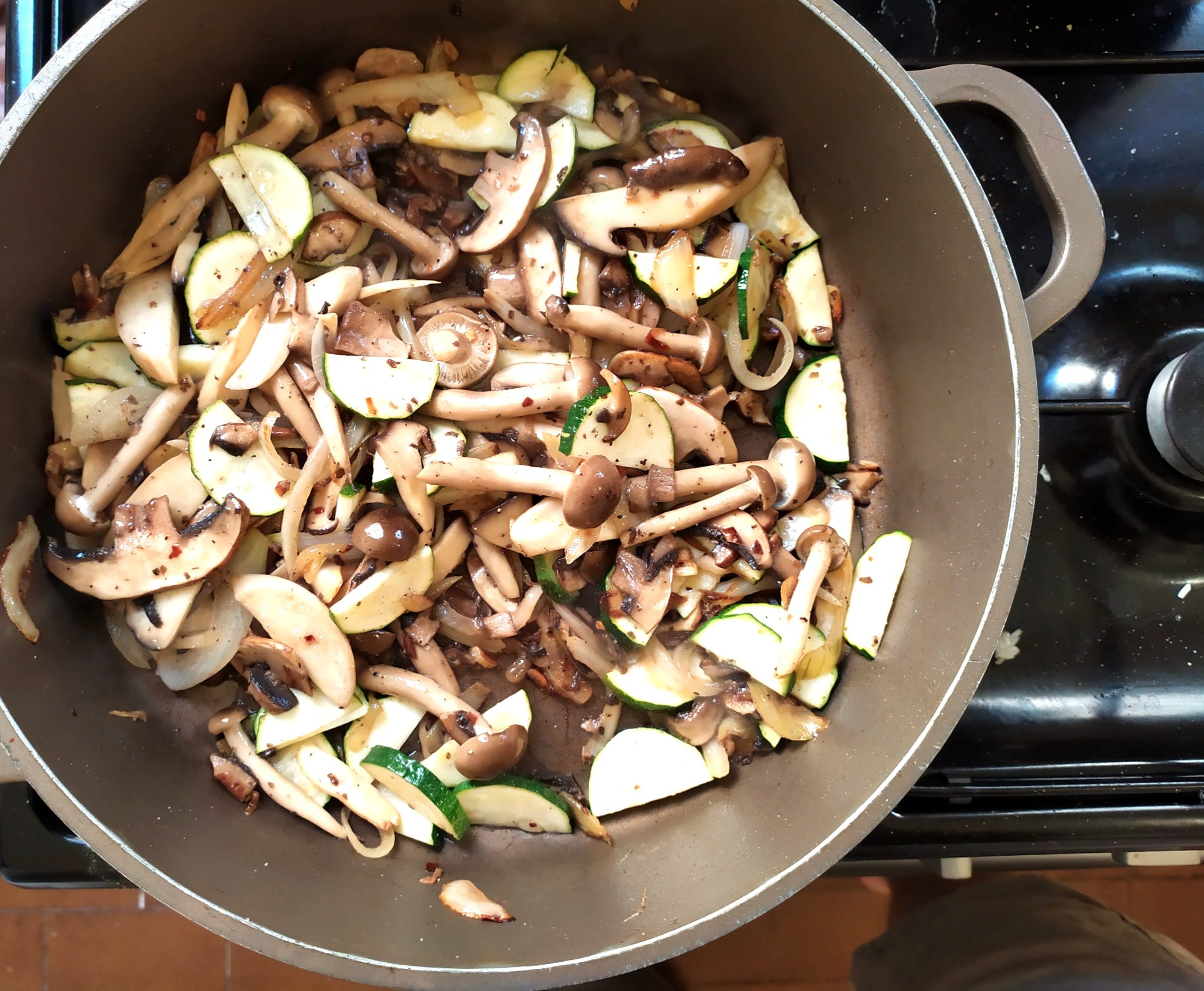 Mixed mushrooms and zucchini cooking in a pan for the mushroom and zucchini pasta recipe