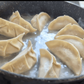 Animated GIF of the lid on the gyoza pan with condensation and steam visible on the glass