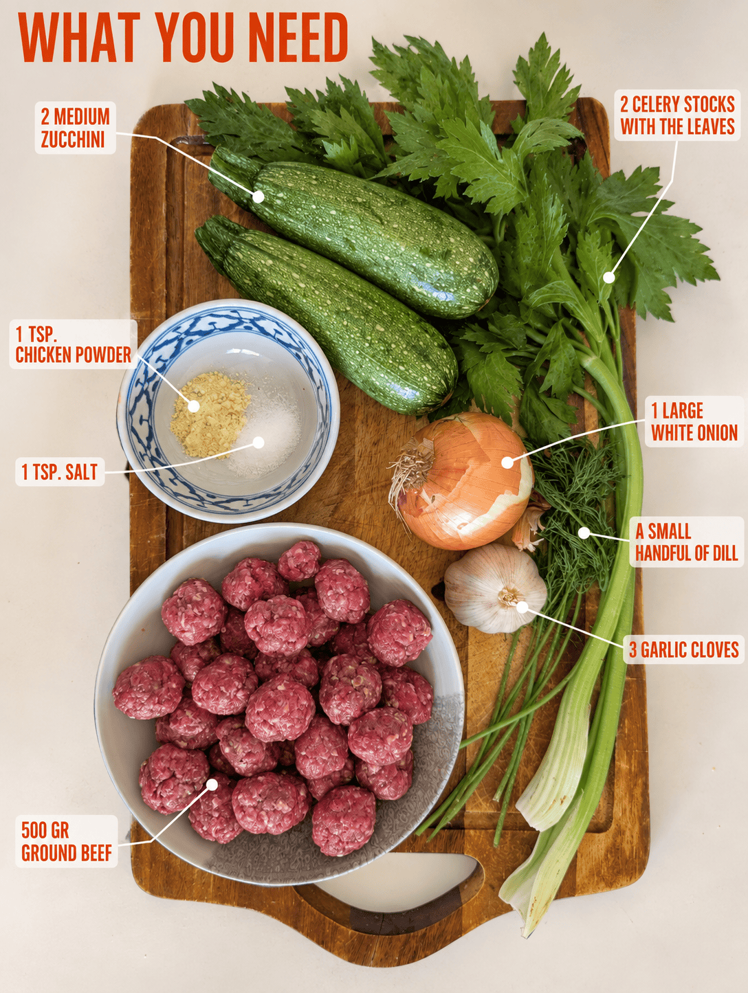 Ingredients for meatball zucchini soup laid out on a wooden board: zucchini, celery, onion, garlic, dill, ground beef, chicken powder and salt